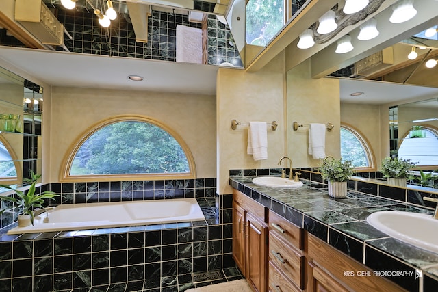 bathroom featuring vanity and tiled tub