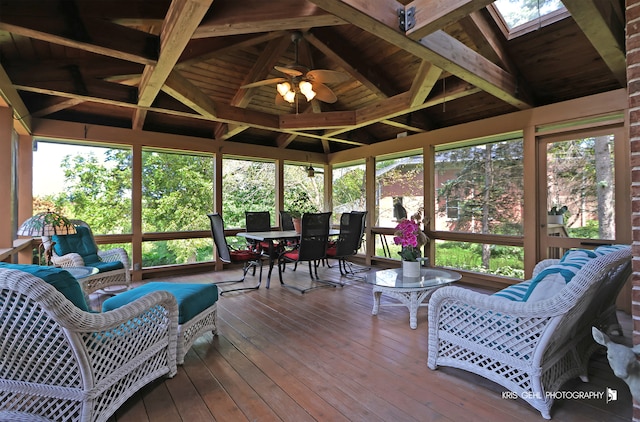 sunroom with vaulted ceiling with skylight, wooden ceiling, and ceiling fan