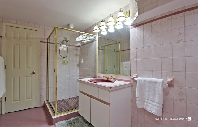 bathroom featuring tile walls, vanity, tile patterned flooring, and an enclosed shower