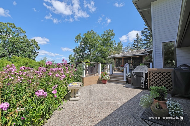 view of patio featuring a wooden deck and a grill