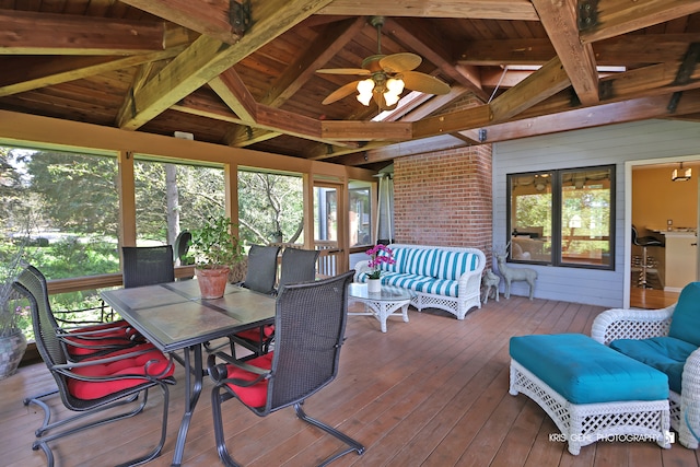 sunroom / solarium with lofted ceiling with beams, wooden ceiling, and ceiling fan