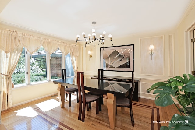 dining room featuring crown molding, a notable chandelier, and wood-type flooring