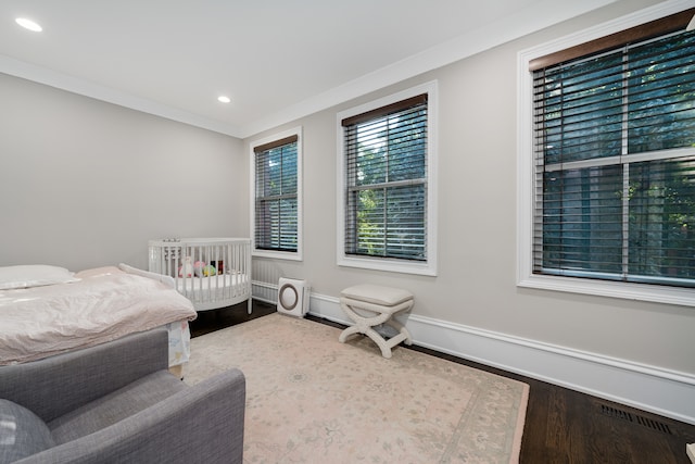 bedroom with ornamental molding and hardwood / wood-style floors