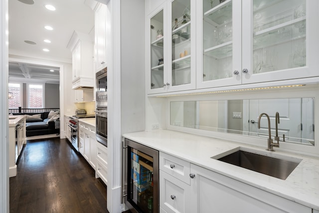 bar with wine cooler, light stone countertops, and white cabinetry