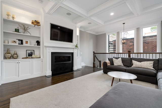 living room with dark wood-type flooring, a notable chandelier, coffered ceiling, and beamed ceiling