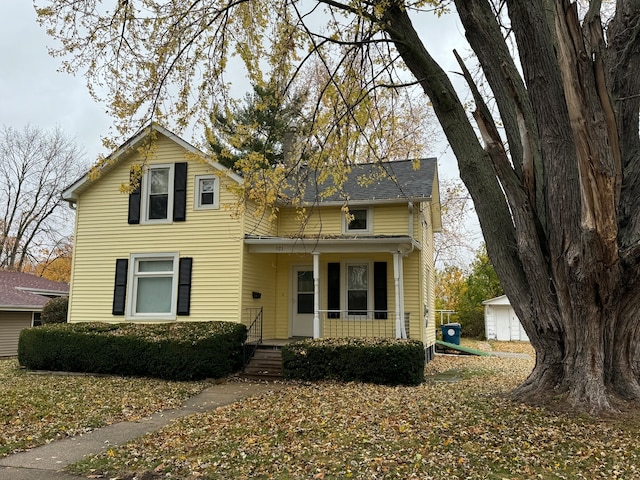 view of property with an outdoor structure, a garage, and a porch