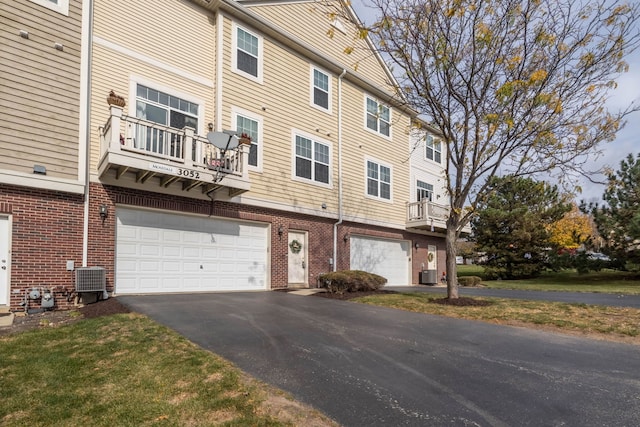 exterior space with central air condition unit and a garage