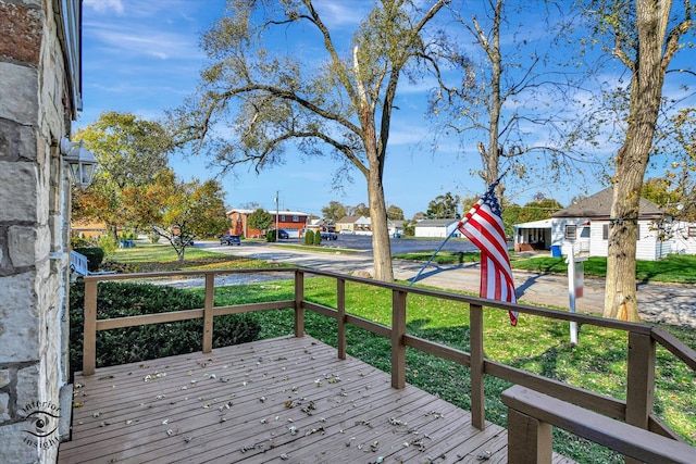 wooden terrace featuring a lawn