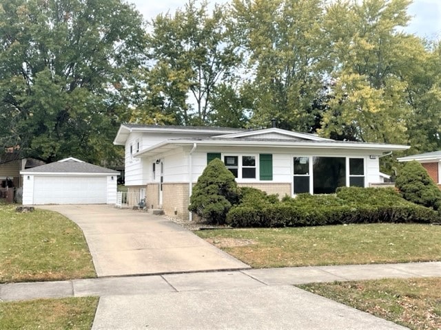 view of front of home featuring a front lawn, an outbuilding, and a garage