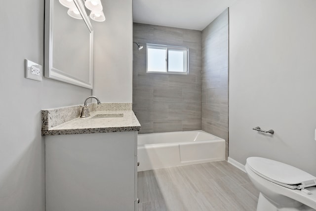 full bathroom with vanity, tiled shower / bath combo, wood-type flooring, and toilet