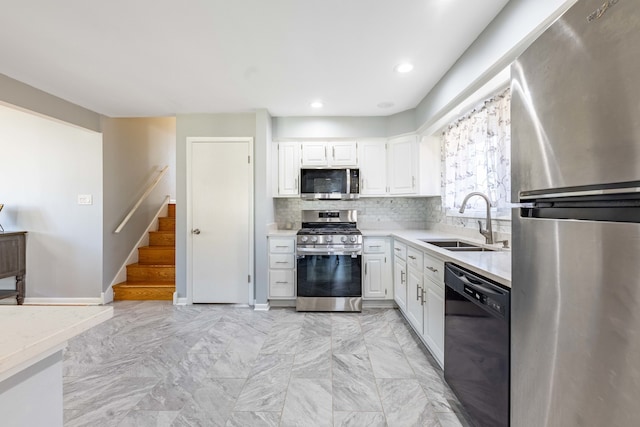 kitchen featuring white cabinetry, sink, backsplash, and appliances with stainless steel finishes