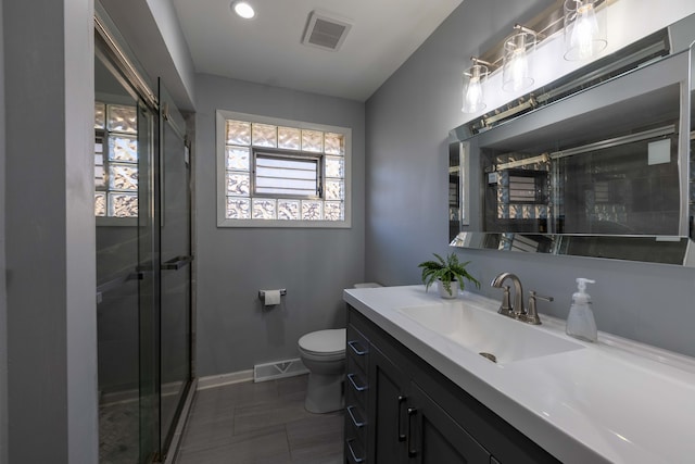 bathroom featuring a shower with shower door, vanity, and toilet