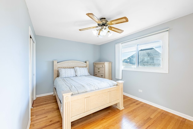 bedroom with a closet, hardwood / wood-style floors, and ceiling fan