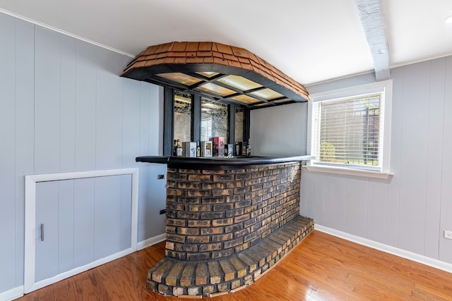 bar with hardwood / wood-style floors and wood walls