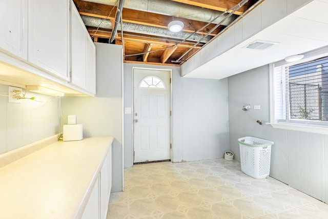 laundry room featuring wood walls and light tile patterned flooring