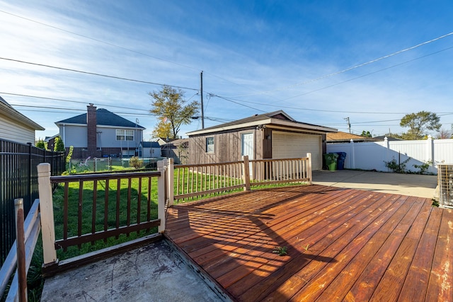 deck featuring a lawn, an outdoor structure, and a garage