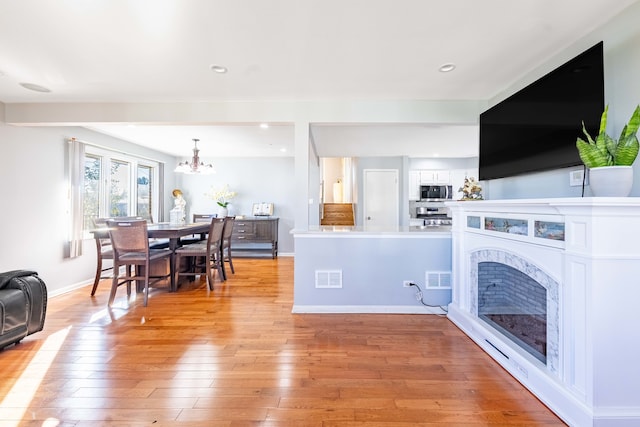 living room featuring light hardwood / wood-style flooring and an inviting chandelier