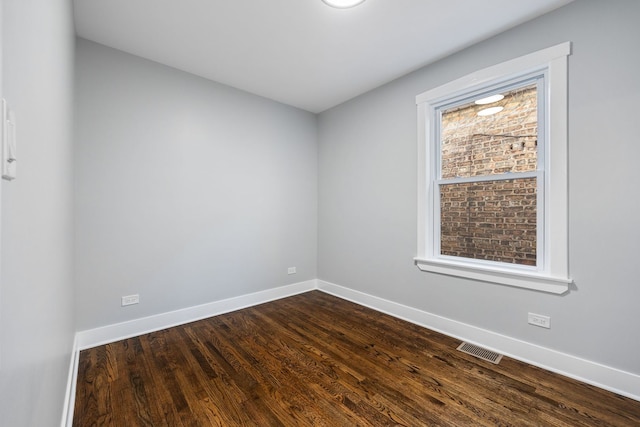 spare room with plenty of natural light and dark hardwood / wood-style floors