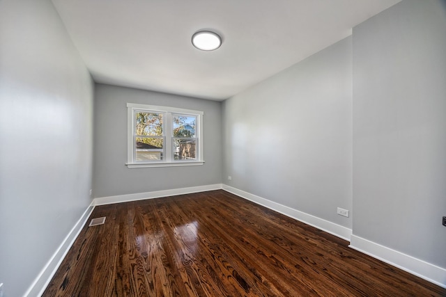 unfurnished room with dark hardwood / wood-style flooring