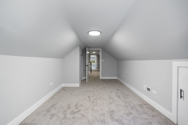 bonus room featuring lofted ceiling and light colored carpet