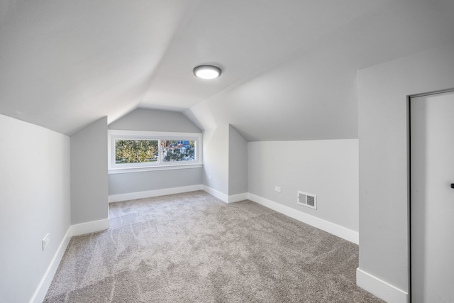 additional living space with vaulted ceiling and carpet floors