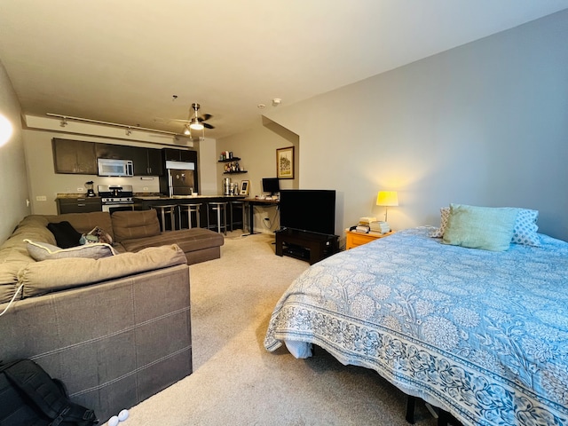 bedroom with light carpet and stainless steel refrigerator