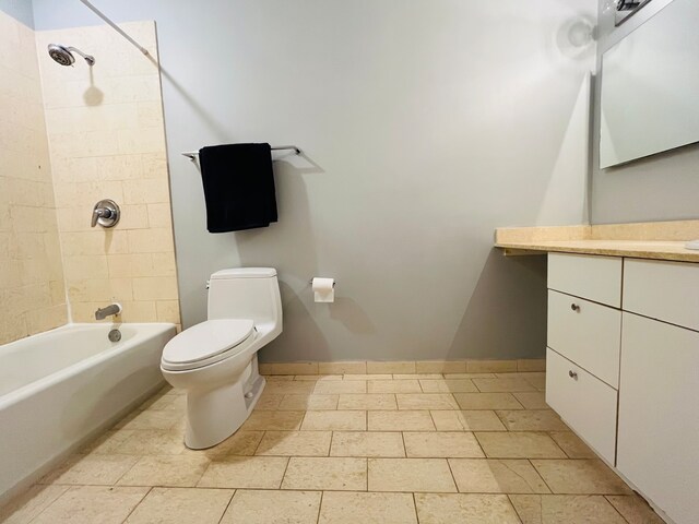 full bathroom featuring tiled shower / bath, vanity, and toilet