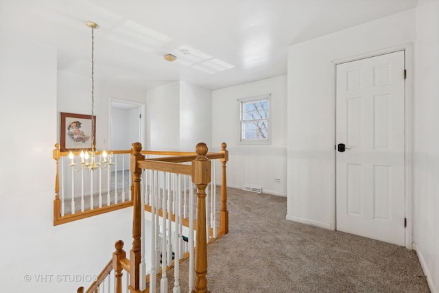 hall featuring a notable chandelier and carpet floors