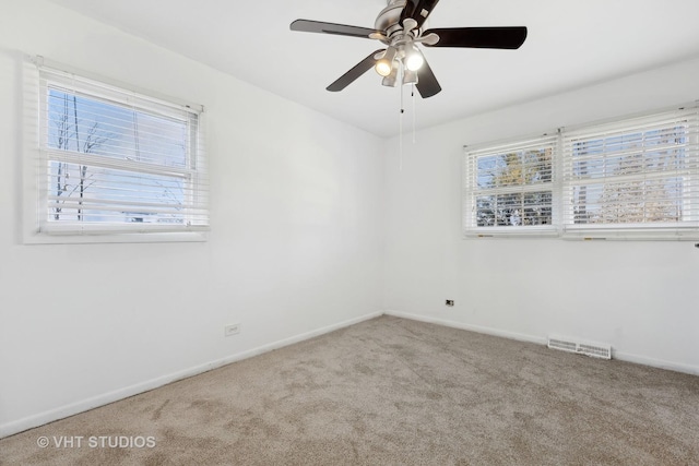 carpeted spare room featuring ceiling fan