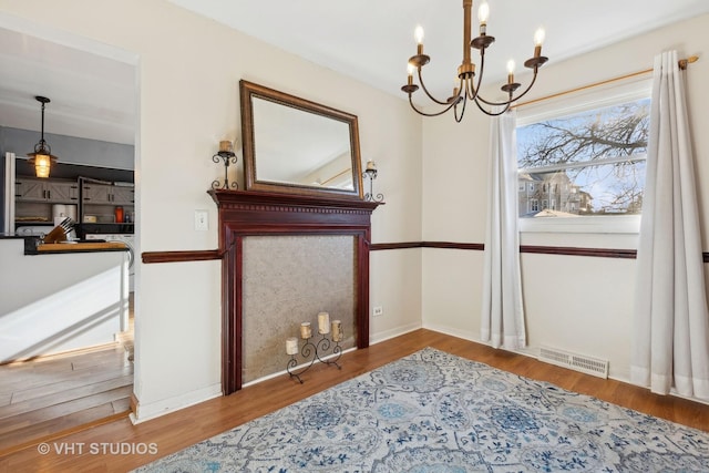 dining room with hardwood / wood-style floors and a notable chandelier