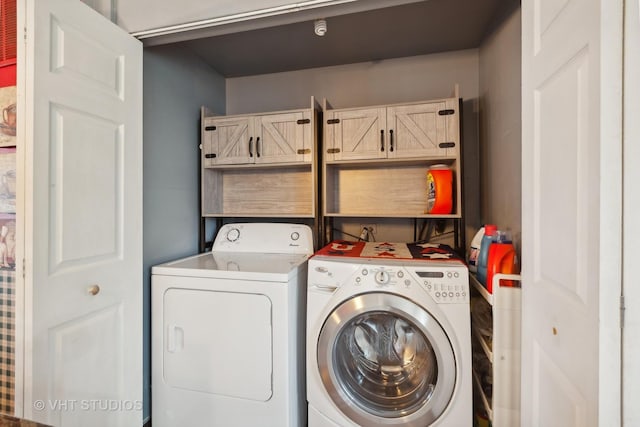 washroom featuring separate washer and dryer and cabinets