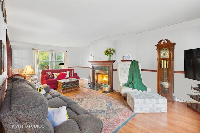 living room featuring hardwood / wood-style flooring and a tiled fireplace