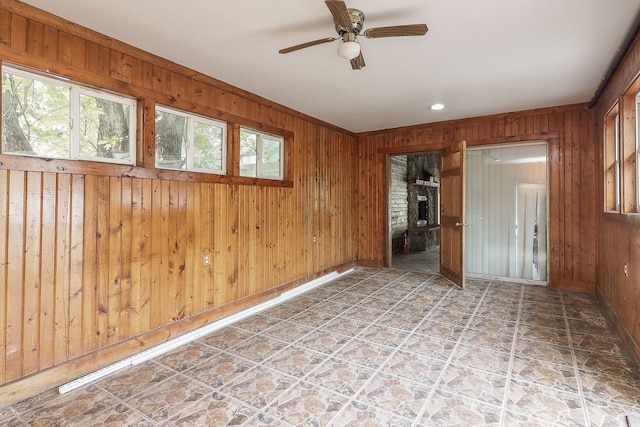 unfurnished room featuring wood walls and ceiling fan