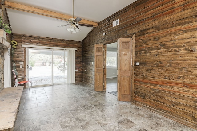 spare room with ceiling fan, wood walls, and vaulted ceiling with beams