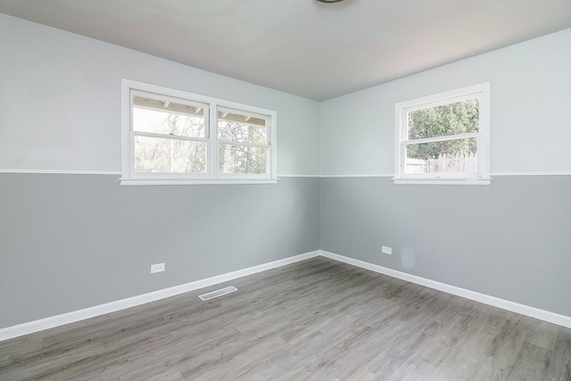 unfurnished room featuring light hardwood / wood-style floors and a healthy amount of sunlight