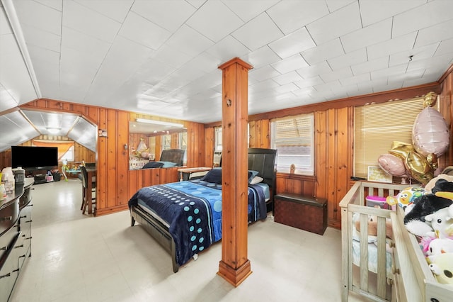 bedroom featuring vaulted ceiling and wooden walls