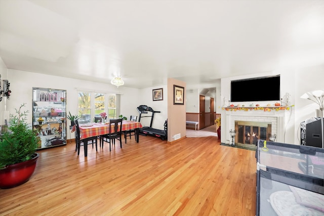 living room featuring a brick fireplace and wood-type flooring