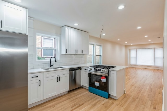 kitchen featuring white cabinetry, appliances with stainless steel finishes, light hardwood / wood-style floors, and plenty of natural light