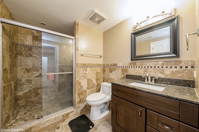 bathroom featuring toilet, walk in shower, vanity, and tile walls