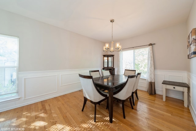 dining area with a chandelier and light hardwood / wood-style flooring