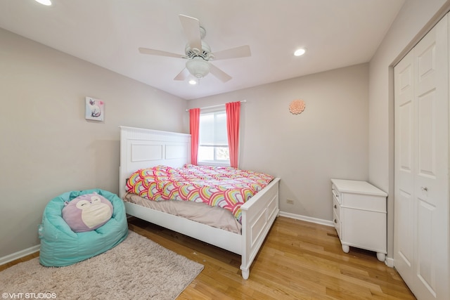 bedroom with light hardwood / wood-style floors, a closet, and ceiling fan