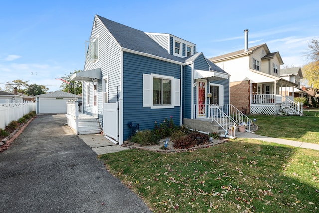 view of front facade with a garage, a front lawn, and an outbuilding