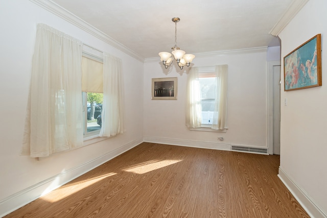 unfurnished dining area with an inviting chandelier, ornamental molding, wood-type flooring, and plenty of natural light