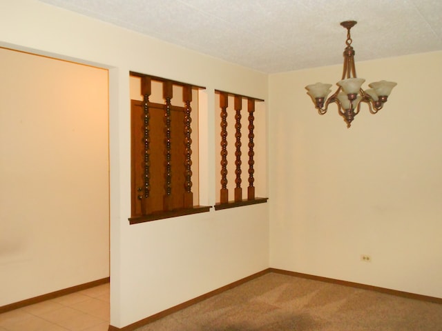 unfurnished room with light carpet, a notable chandelier, and a textured ceiling