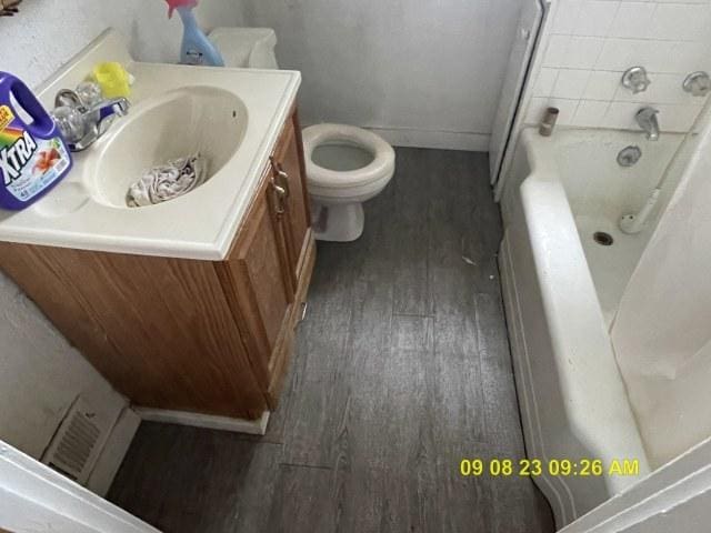 305 River Oaks Dr, Calumet City, IL 60409 - bathroom featuring vanity, a bath, wood finished floors, and toilet