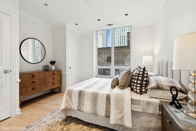 bedroom featuring crown molding and light wood-type flooring