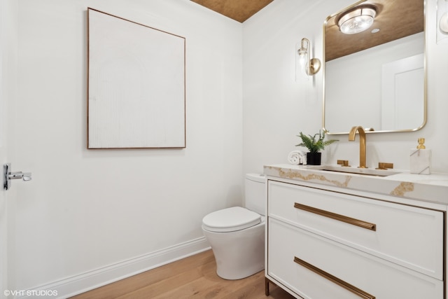 bathroom featuring vanity, toilet, and hardwood / wood-style flooring