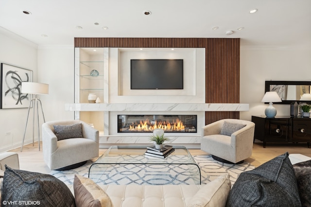 living room featuring a premium fireplace, light hardwood / wood-style flooring, and ornamental molding