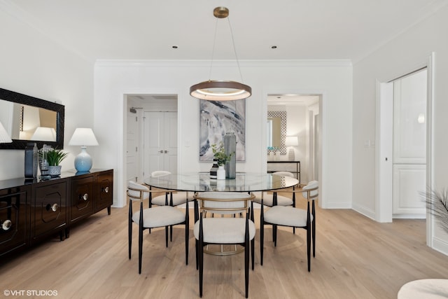 dining space with light hardwood / wood-style flooring and crown molding