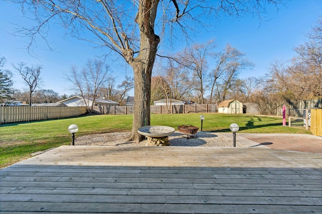 wooden terrace featuring a yard and an outdoor fire pit